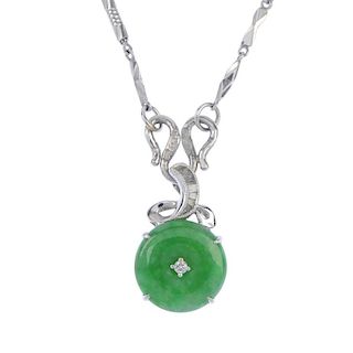 A jade and diamond pendant. The jadeite disc with brilliant-cut diamond highlight, suspended from a