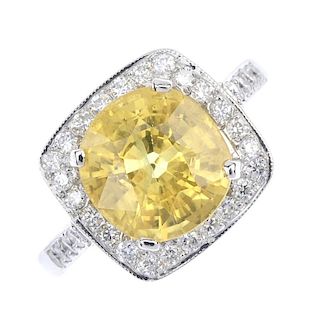 A sapphire and diamond dress ring. The cushion-shape yellow sapphire, with brilliant-cut diamond sur