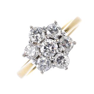 A diamond cluster ring. Of floral design, the brilliant-cut diamond cluster, to the tapered shoulder