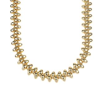 An 18ct gold collar. Designed as a series of tapered links, set at alternating orientations, to the