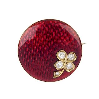 An early 20th century gold diamond and enamel brooch. The red guilloche enamel slightly domed disc,
