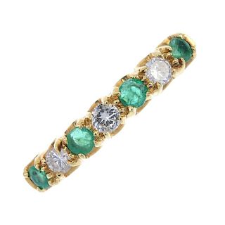 An 18ct gold emerald and diamond seven-stone ring. The alternating brilliant-cut diamond and circula