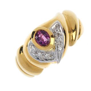 An 18ct gold ruby and diamond dress ring. The oval-shape ruby collet, with crossover brilliant-cut d