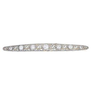 An early 20th century diamond bar brooch. Designed as a series of graduated old-cut diamond collets,