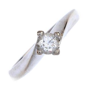 An 18ct gold diamond single-stone ring. The brilliant-cut diamond, to the asymmetric shoulders and t