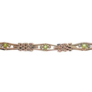 An early 20th century 9ct gold peridot and split pearl bracelet. Designed as a series of circular-sh