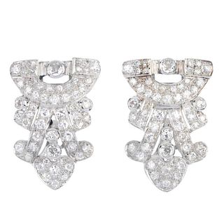 A pair of mid 20th century diamond clip brooches. Of openwork design, the geometric panels, set thro