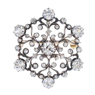 A late 19th century silver, gold and diamond pendant. Of openwork design, the scrolling line panel,