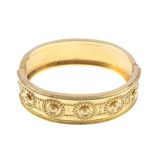 A late Victorian 15ct gold hinged bangle. Designed as a series of floral cannetille discs, with simi