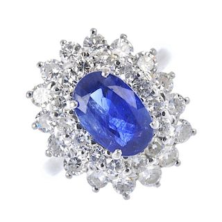 A sapphire and diamond cluster ring. The oval-shape sapphire, within a brilliant-cut diamond double