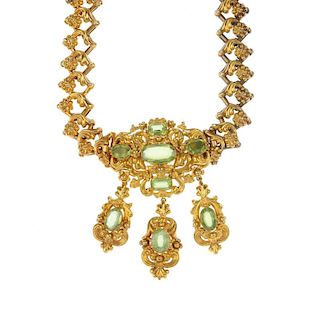 A mid 19th century peridot necklace, brooch and earring. Designed as a detachable scrolling foliate