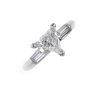 A diamond single-stone dress ring. The triangular-shape diamond, with baguette-cut diamond sides, to
