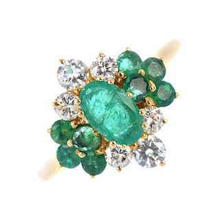 An 18ct gold emerald and diamond dress ring. The oval-shape emerald, within a brilliant-cut diamond