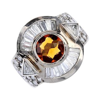 A citrine and diamond dress ring. The circular-shape citrine collet, with tapered baguette-cut and t