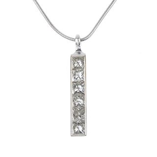 THEO FENNELL - a diamond pendant. The square-cut diamond line, within a plain surround, to the openw