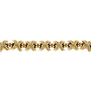 TIFFANY & CO. - a 'Kisses' bracelet. Designed as a series of crossed bars, interspaced by grooved li