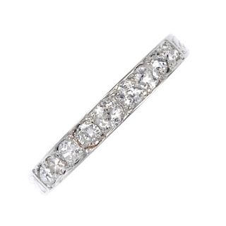 A mid 20th century gold and platinum diamond band ring. The graduated vari-cut diamond line, within