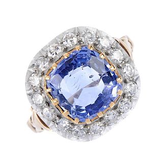 An early 20th century gold and silver sapphire and diamond cluster ring. The cushion-shape sapphire,