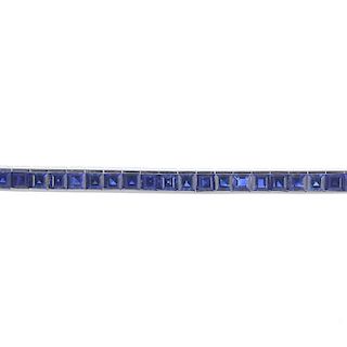 A sapphire bracelet. Designed as a square-shape sapphire line to the partially concealed clasp. Fore
