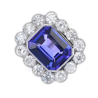 A tanzanite and diamond cluster ring. The rectangular-shape tanzanite collet, within a brilliant-cut