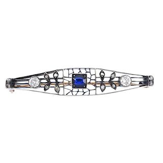 An early 20th century silver and gold, sapphire and diamond brooch. Of openwork design, the oval-sha