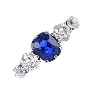 An 18ct gold sapphire and diamond five-stone ring. The oval-shape sapphire, with graduated old-cut d