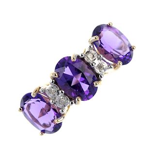 An 18ct gold amethyst and diamond ring. The oval-shape amethyst line, between single-cut diamond spa