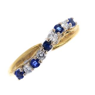 An 18ct gold sapphire and diamond crossover ring. The alternating brilliant-cut diamond and circular