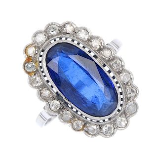 A synthetic sapphire and diamond cluster ring. The oval-shape synthetic sapphire collet, within a si