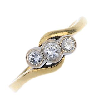 An 18ct gold diamond three-stone crossover ring. The graduated brilliant-cut diamond collets, to the