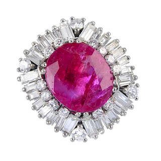 A ruby and diamond cluster ring. The oval-shape ruby, within a brilliant-cut diamond border, to the