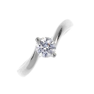 A platinum diamond single-stone ring. The brilliant-cut diamond, to the asymmetric shoulders and pla