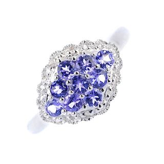 An 18ct gold tanzanite and diamond ring. The circular-shape tanzanite, marquise-shape panel, within
