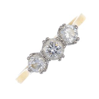 An 18ct gold diamond three-stone ring. The brilliant-cut diamonds, to the tapered shoulders and plai