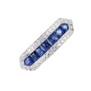 A sapphire and diamond dress ring. The calibre-cut sapphire line, within a brilliant-cut diamond sur