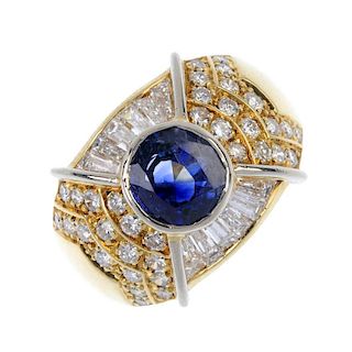 A sapphire and diamond dress ring. The circular-shape sapphire collet, with tapered baguette-cut dia