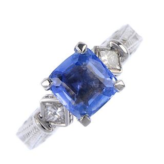 A sapphire and diamond dress ring. The cushion-shape sapphire, to the square-shape diamond collet si