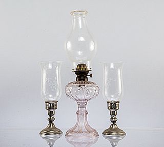 Lote de 3 piezas. Siglo XX. Elaborados en pewter y vidrio prensado con aplicaciones de metal. Consta de: Quinqué y par de candeleros.