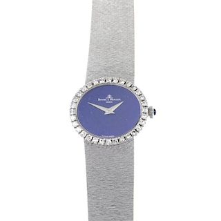 BAUME & MERCIER - an 18ct gold diamond wristwatch. The oval-shape blue dial, within a single-cut dia