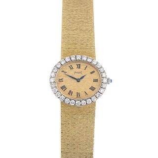 PIAGET - an 18ct gold diamond dress watch. The oval textured dial, with black Roman numerals, to the