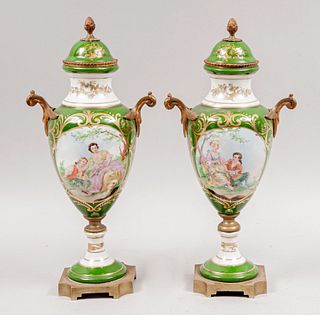 Par de tibores. Francia, siglo XX. Elaborados en porcelana limoges, color verde. Con aplicaciones de metal dorado en bases.