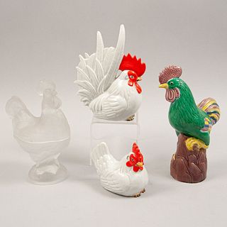 Lote de 4 gallos y gallinas. Siglo XX. Elaborados en cerámica, porcelana policromada y vidrio opaco.