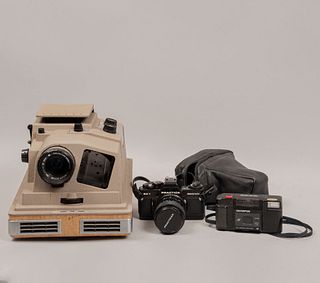 Lote de 2 cámaras fotográficas y proyector con estuche. Siglo XX. Elaboradas en metal, baquelita y material sintético.