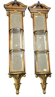 Pair of carved and gilt hanging shelves having mirrored backs, height 60 inches, width 12 inches.