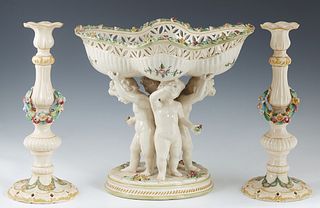 Dresden Style Three Piece Earthenware Garniture Set, 19th c., consisting of a reticulated undulating center bowl upheld by three putti, on an integral