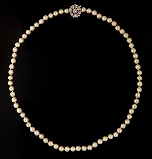 Strand of 7.8 mm White Cultured Pearls, with a 14K floriform white gold clasp/enhancer, the center mounted with a 15 point round diamond surrounded on