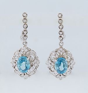 Pair of 14K White Gold Hoop Earrings, the diamond mounted half-hoops with a pendant oval blue zircon atop a pierced diamond mounted border, total zirc