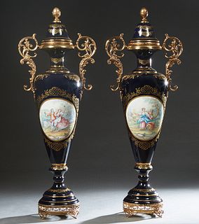 Large Pair of Sevres Style Ormolu Mounted Covered Handled Cobalt Porcelain Urns, 20th c., of baluster form, with gilt decoration and paint enhanced re