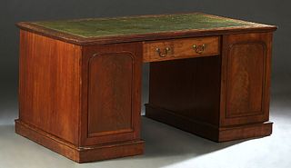 English Carved Mahogany Partner's Desk, early 20th c., the gilt tooled green leather top on double pedestals, joined by a center drawer, each with fou