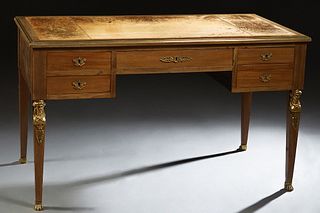 French Empire Style Ormolu Mounted Carved Mahogany Desk, 19th c., the stepped bronze edge top with a central brown leather insert, over a wide skirt w